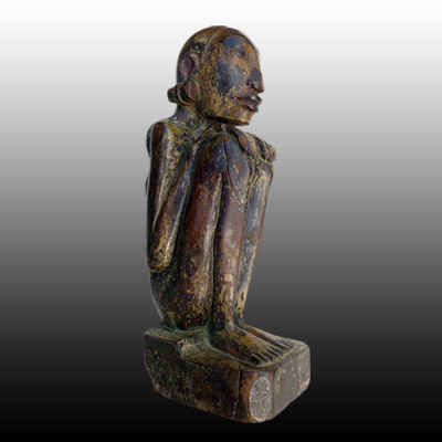 Bali female anamist figure of slender form and seated in a typical hunkerred position